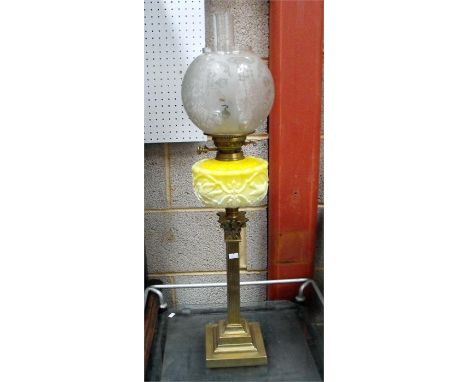 An Edwardian oil lamp, the etched glass shade above a yellow glass reservoir, decorated with birds and standing on a square b
