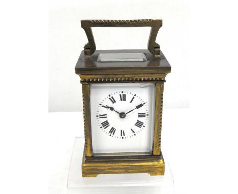 A French brass carriage clock or timepiece, the enamel dial having roman numerals, 11cm high. 
