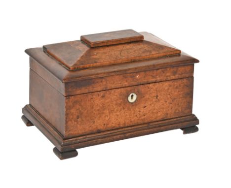An early Victorian burr yew wood and mahogany tea caddy, of sarcophagus shape, the lid with sliding platform revealing a spac