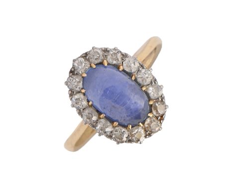 A sapphire and diamond ring, the single sapphire cabochon surrounded by evenly sized old cut diamonds, gold hoop, marks worn,