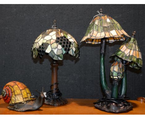 Three Tiffany style table lamps, largest 50cm h  Minor hairline cracks to shade of toadstool lamp