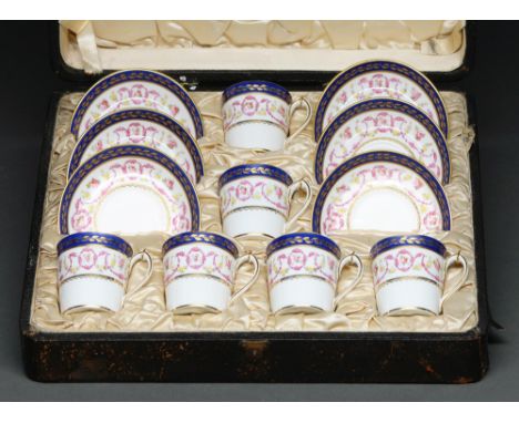 A set of six Royal Crown Derby bucked shaped coffee cups and saucers, 1912, painted with festoons in Smith's blue and gilt bo