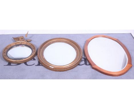 A Regency style giltwood convex wall mirror40cm diameter; A modern gilt framed oval wall mirror, 64cm wide; and a modern maho