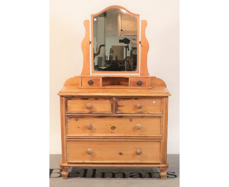 A Victorian pine dressing chestArched mirror over two short and two long drawers on turned supports, 98cm wide; 155cm high