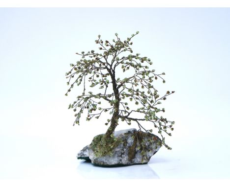 A green gem set and wirework ornamental treeMounted on a quartz boulder, 24cm highCondition report:&nbsp;A few stones are loo