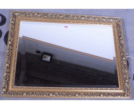 A modern gilt framed mirrorWith floral chased frame, 82cm wide; 62cm high