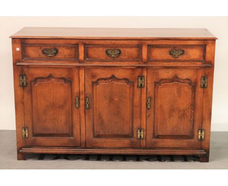 An 18th century style oak dresser baseThree drawers over cupboard base, 139cm wide; 90cm high