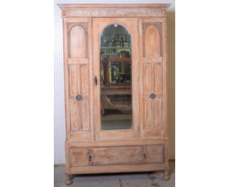 An early 20th century oak wardrobeWith central arched mirrored door over single drawer base, 122cm wide; 203cm high