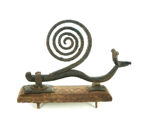 A novelty wrought iron door knocker in the form of a snail, on oak backing plate30cm long