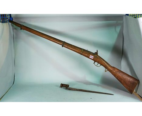 An early 20th century percussion action rifle and Bayonet, possibly converted from a flintlock gun.Chips to the wooden frame.