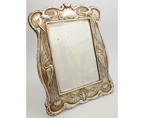 Art Nouveau silver easel mirror, of shaped rectangular form, with herons, lotus flowers and stylized plants by William Aitken