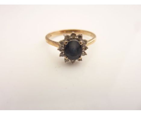 A sapphire and diamond ring, centred with an oval mixed-cut sapphire weighing approximately 0.66cts, within a border of twelv