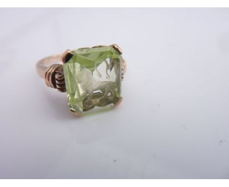 A carved intaglio gem-set ring, claw-set with green gemstone, possibly peridot, carved with a Leo intaglio, in 9ct gold, size