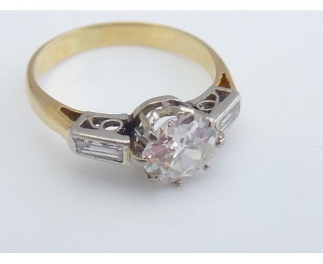 A diamond ring, centred with a claw-set old brilliant-cut diamond weighing approximately 0.94cts, flanked to each shoulder wi