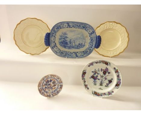An early 19th century serving dish of oval form with moulded handles, with blue and white decoration of a rural landscape wit