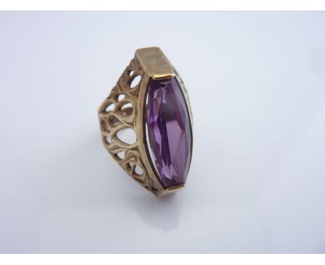 A synthetic alexandrite dress ring, with openworked scrolling shoulders, in 9ct gold, size O