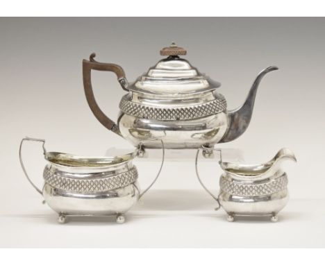 George III silver three piece tea set, each piece having a band of diamond embossed decoration and standing on four ball feet