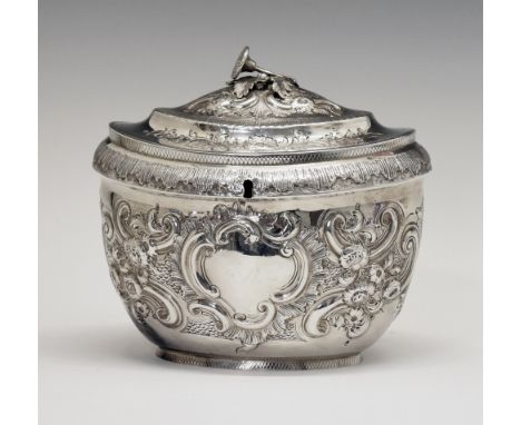 George III oval silver tea caddy having later embossed decoration, the hinged cover opening to reveal a partitioned interior,