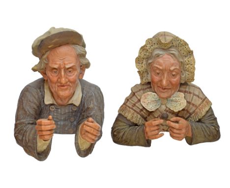 Pair of early 20th Century Austrian terracotta figural wall plaques, modelled as an elderly man and woman wearing traditional