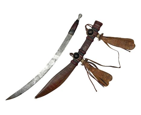 Mandingo sword with 63cm plain curving steel blade and leather covered grip with white metal ribbed spherical pommel; in deco