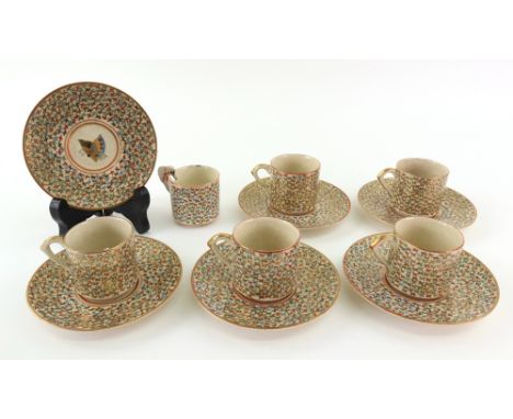 A set of six Japanese Satsuma small coffee cups and saucers, Meiji, each painted with a butterfly against a ground filled wit