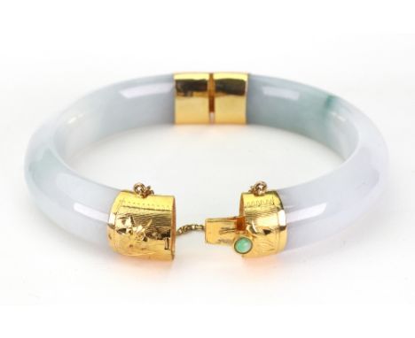 A pale mottled green jade circular hinged bangle, the yellow metal mounts and integral clip with cabochon jade button and sim