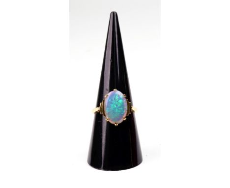 A yellow gold and cabochon white opal ring, the oval opal in a six double-claw setting between stepped Art Deco style shoulde