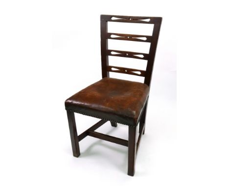 A set of six George III provincial oak dining chairs, with pierced ladder backs, close nailed leather upholstered stuff over 