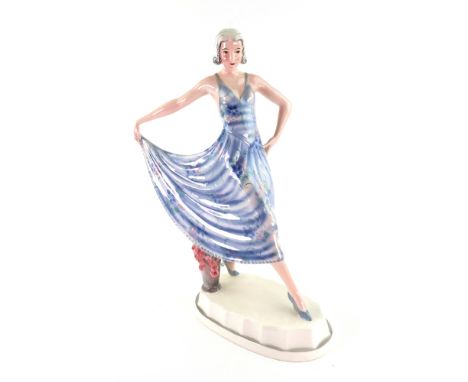 A Goldscheider hand decorated pottery figure of a fashionable young lady, circa 1930, designed by Lorenzl, her blue stripped 