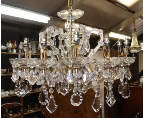 An Italian glass and gilt metal 12-light chandelier, second half 20th century, with scrolled branches and applied flowerheads