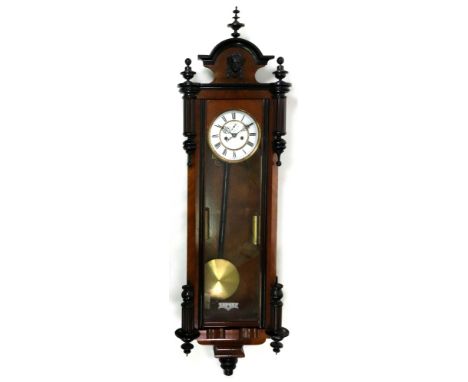 A Vienna style regulator wall clock, circa 1890, in a walnut and ebonised case, the moulded arched top above a carved mask an