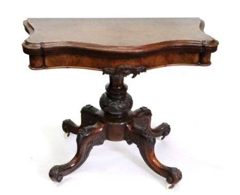 A Victorian walnut card table, circa 1860, the hinged swivel burr veneered fold over top of serpentine outline, on a carved a