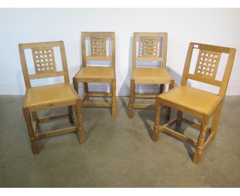 A set of four Robert Thompson of Kilburn "Mouseman" single oak dining chairs with lattice backs and pale brown leather seats,