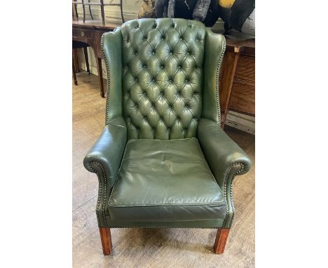 A green wingback button armchair 