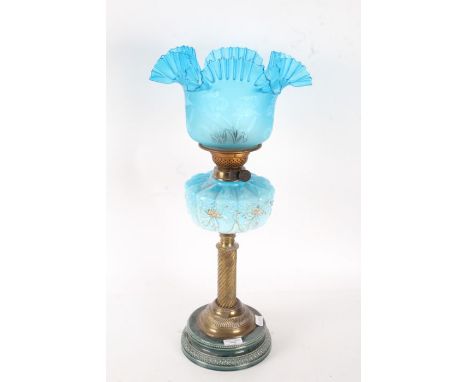 A Victorian oil lamp, with a blue ceramic base with a reeded brass stem above a pale blue and gilt opaque reservoir and a blu