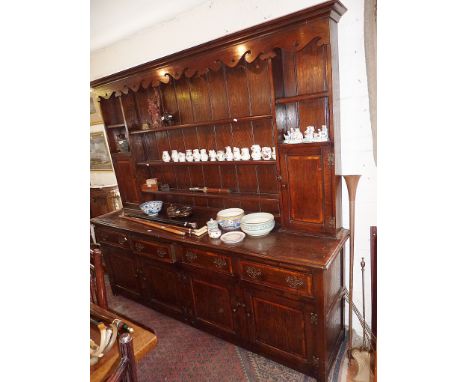 Georgian style cross-banded oak Farmhouse dresser with shaped frieze, the rack with two spice cupboards above the base with f
