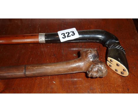 Walking stick with hoof shaped horn handle and silver band and a similar with two grotesque carved heads grip