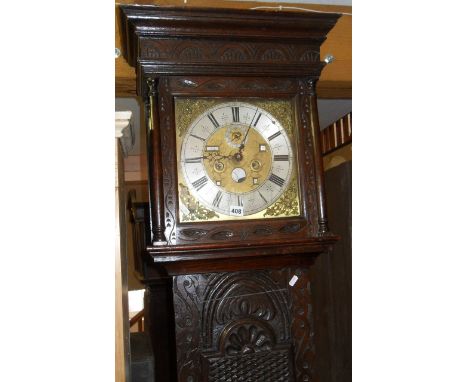 18th c. 8 day Grandfather clock in a Victorian carved oak case. Brass face and silver chapter ring with moon face and date ap