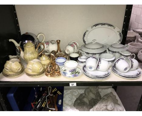 A shelf of crockery including tea sets etc.,