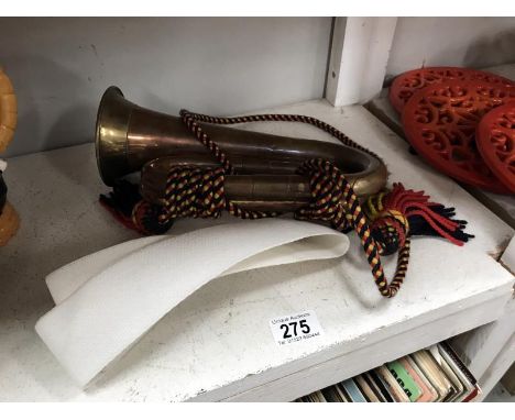 A copper and brass bugle and belt.