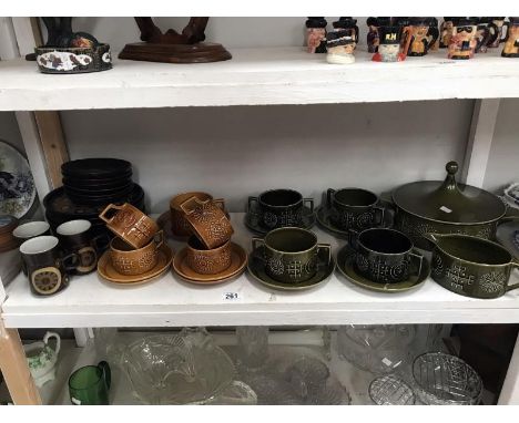 A shelf of Portmerion and Denby pottery.