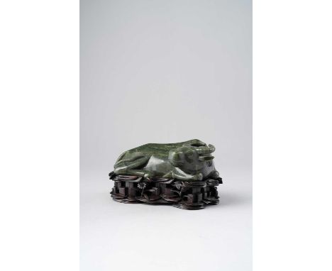 A CHINESE SPINACH-GREEN JADE CARVING OF A WATER BUFFALO20TH CENTURYThe recumbent beast with its head turned to the right, the