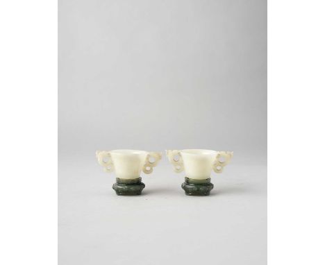 NO RESERVEA PAIR OF CHINESE WHITE JADE CUPS AND SPINACH-GREEN JADE STANDS QING DYNASTY  The cups raised from short tapered fe