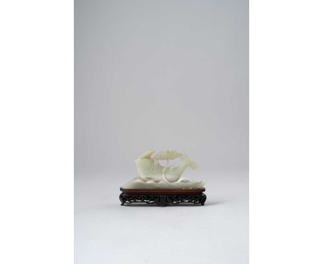A CHINESE CELADON JADE CARVING OF A CARPQING DYNASTYEmerging from rolling waves, its upturned body curving towards a lotus fl