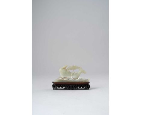 A CHINESE CELADON JADE CARVING OF A CARPQING DYNASTYEmerging from rolling waves, its upturned body curving towards a lotus fl