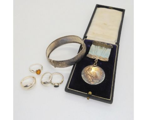 A silver The London College of Music medal, silver rings and a bangle Condition Report:Not available for this lot.