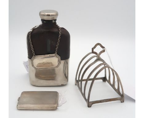 A white metal and glass hip flask, the top half of the body covered with leather, with a silver gin decanter label, by Franci