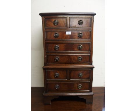 A 20th century mahogany apprentice style chest on chest with two over three drawer on a two over one base with bracket feet, 
