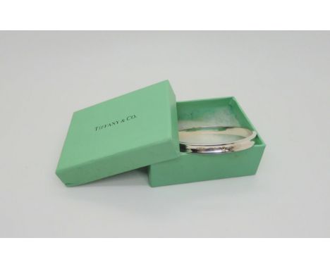 A silver Tiffany &amp; Co bangle, in original box, the bangle stamped 925 T&amp;Co 1837 and to the inner bangle 'Copyright lo
