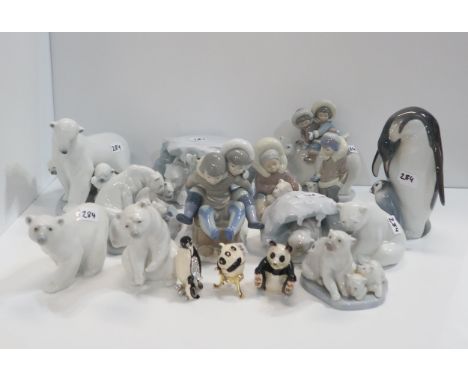 A collection of Lladro polar bear and Eskimo figures together with a penguin and chick figure and three enamel trinket boxes 